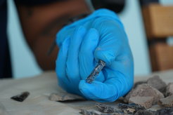 A researcher handles a shard of obsidian