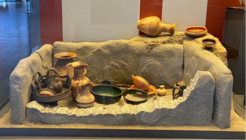 Rekonstruktion eines Kindergrabes aus dem 8. bis 7. Jahrhundert v. Chr. mit etruskischen Keramikgefäßen, die als Grabbeigaben deponiert wurden (MAP - Museo Archeologico di Pontecagnano)